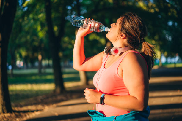 istock Oversized woman drinking water after running 1172467858