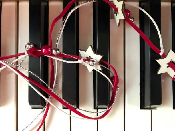 Holiday ribbon on piano keys to represent classical, holiday, or Christmas music.