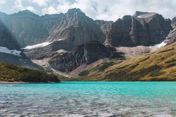 istock Blue Galcier Lake with Mountains, Cliffs and Snow in Background 1172473521