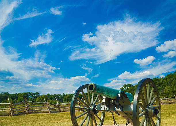 Cannon at Gettysburg American Civil War bronze cannon weathered with age to a pale greenish hue rests at Gettysburg National Military Park, Gettysburg, Pennsylvania, USA.  A "Virginia Worm Fence", also known as a "Sawbuck Fence" divides the hallowed grounds. This picture was taken near the Eternal Light Peace Memorial. gettysburg national military park stock pictures, royalty-free photos & images