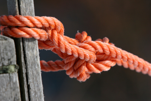 An orange rope tired in a tight knot.