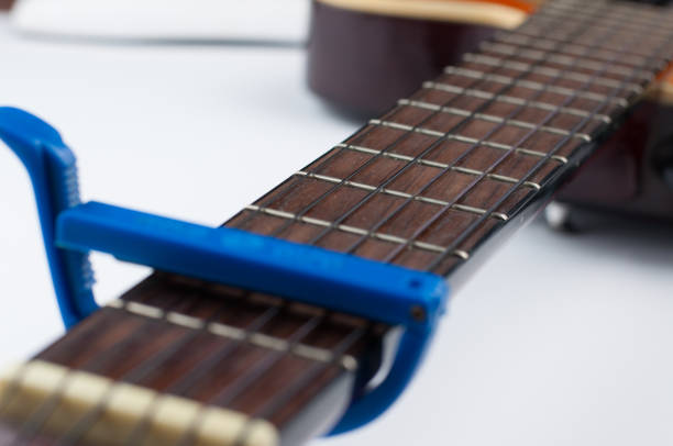 istock Blue guitar capo and guitar isolated on white background 1172481054