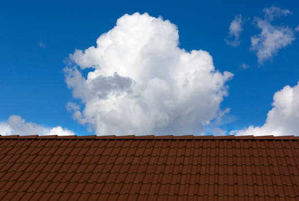 Roof house with blue sky and clouds.  Tiles roof and sky on sunny day.