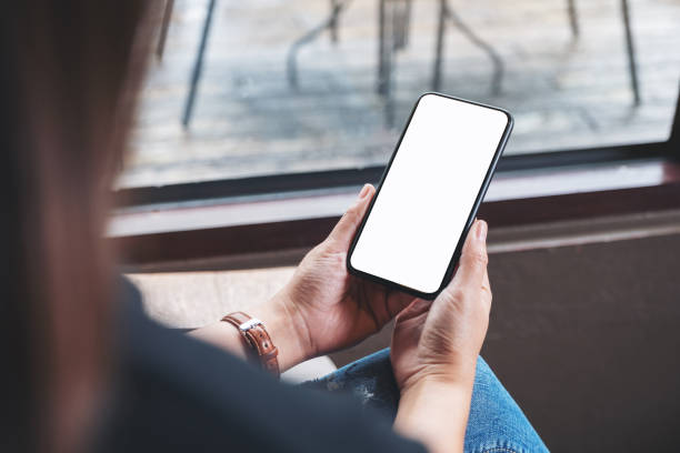 istock a woman holding black mobile phone with blank desktop screen 1172484353