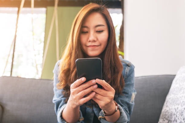 istock a beautiful asian woman holding , using and looking at smart phone 1172484458