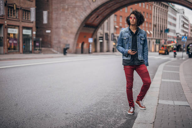 istock Modern young man using phone on the street 1172486624