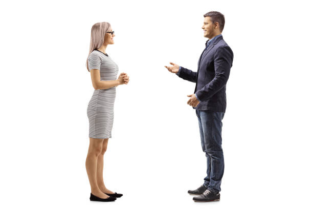 Yung man and woman standing and talking Full length profile shot of a young man and woman standing and talking isolated on white background man standing profile stock pictures, royalty-free photos & images