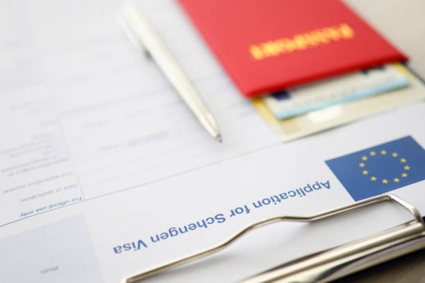 istock Red passport with silver pen lie against schengen 1172487087