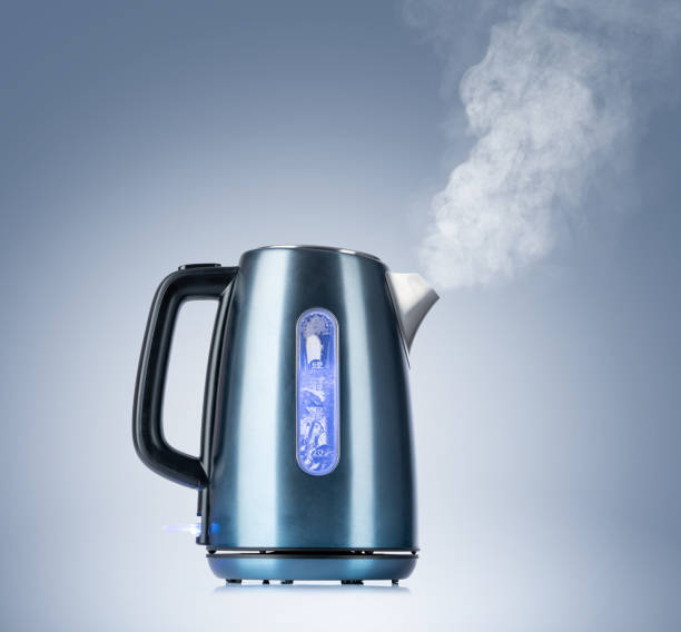 istock Boiling electric kettle gives off steam on blue background 1172487945