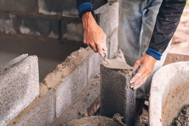 istock hand of worker plastering cement on brick wall at construction site 1172488405