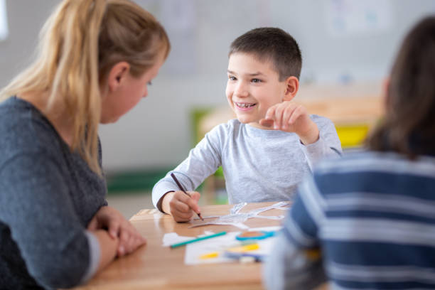 istock Boy talking with his teacher in the classroom 1172490498
