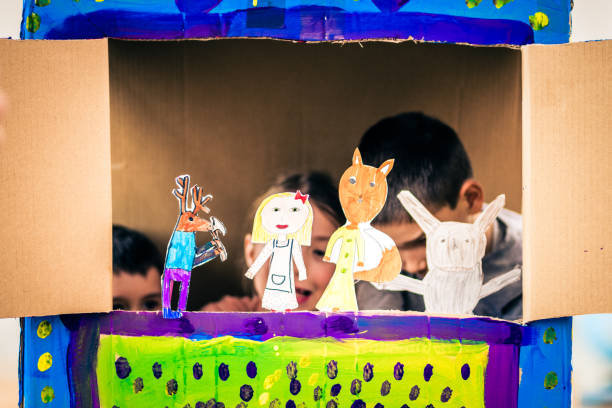 Children playing with paper puppets stock photo