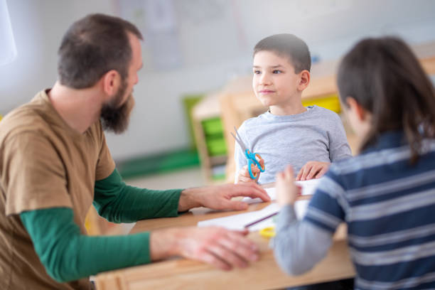 istock Teacher and students sitting in classroom 1172490544