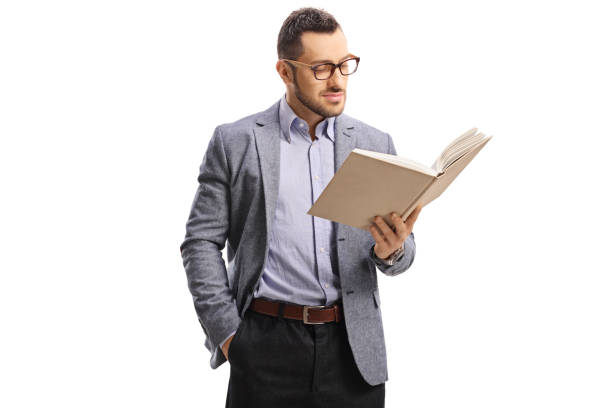istock Young man with glasses standing and reading a book 1172490555
