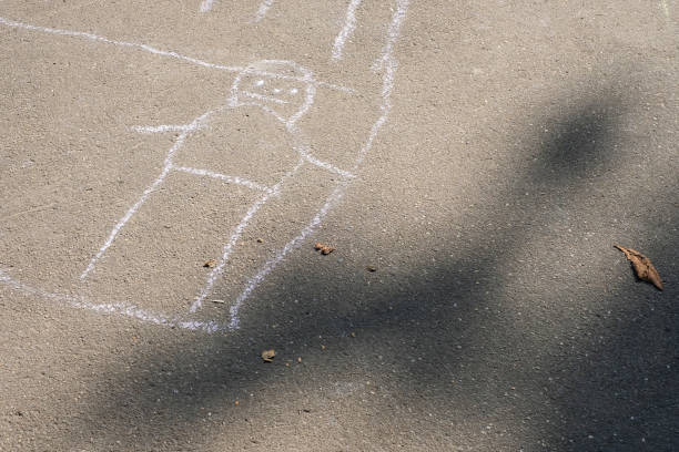 Chalk drawing of figure of man or woman on asphalt. Children's creativity in the summer, the development of imagination. stock photo