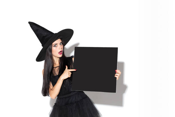 istock Young woman in hat and dress as a witch on white background 1172491237