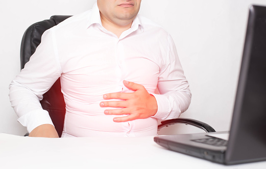 Trabajador de oficina masculino sosteniendo estómago, gastritis y úlcera estomacal, Helicobacter pylori. photo
