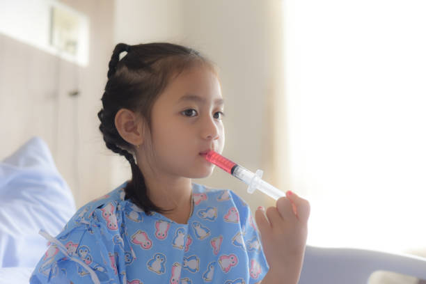 istock Patient child using oral syringe to take liquid medicine 1172502683