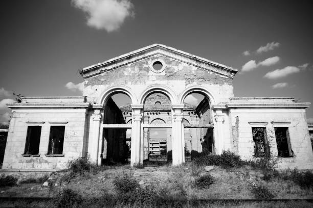 istock Abandoned partially ruined white building with wild plants growing inside. 1172502890
