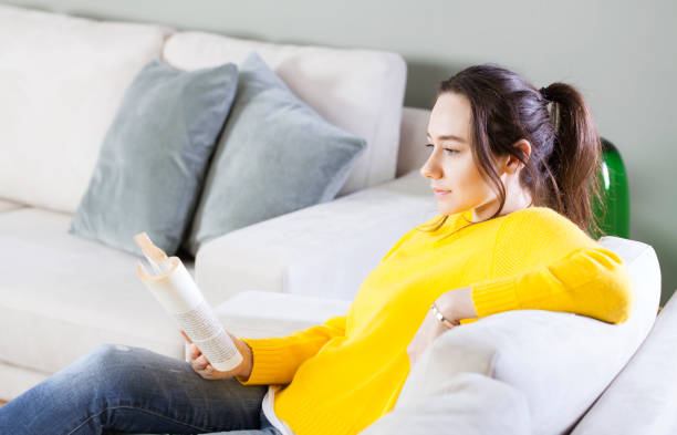 istock Woman reading the book at home 1172503797