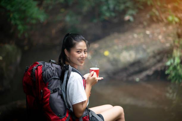 istock Backpacker woman drinking hot coffee in forest 1172505616