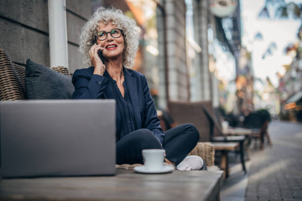 istock Senior woman talking on mobile outdoors in cafe 1172508216