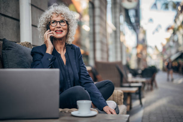 istock Senior lady talking on mobile outdoors in cafe 1172508461