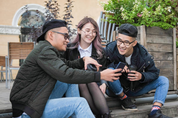 istock Three friends sit on the steps on the street. 1172515294