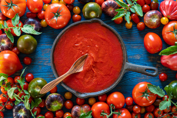 Fried tomato sauce with tomatoes on wood Fried tomato sauce with tomatoes composition on wooden board tomato sauce stock pictures, royalty-free photos & images