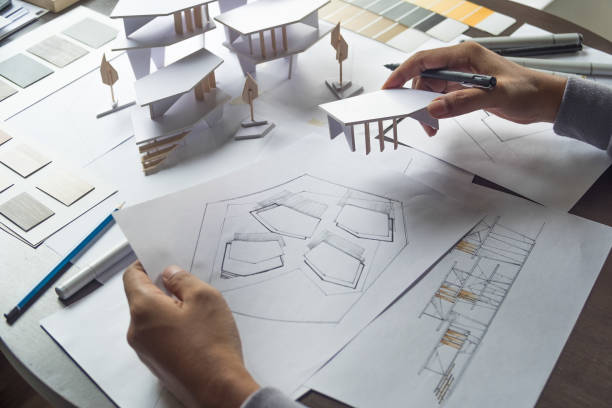 istock architect design working drawing sketch plans blueprints and making architectural construction model in architect studio 1172518395