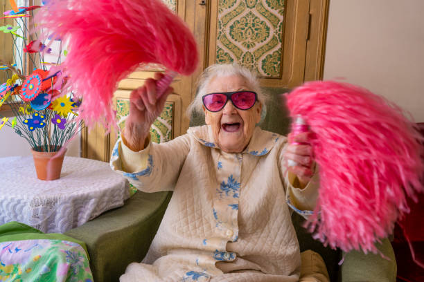 Cheerleader pom-pom elderly woman happy Cheerleader pom-pom elderly woman happy at living room fan enthusiast photos stock pictures, royalty-free photos & images