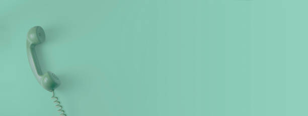 istock A green vintage dial telephone handset with green background. 1172530598