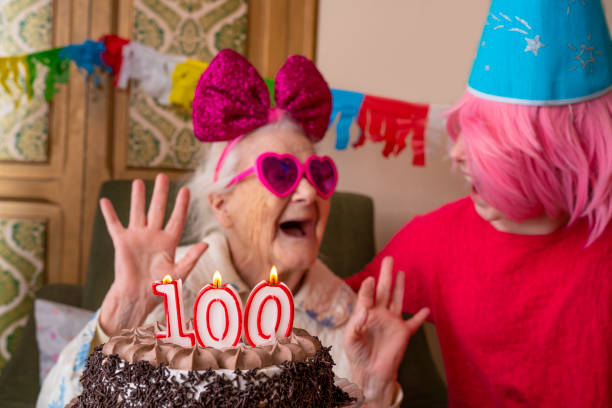 老婦人高齢者に100歳のバースデーケーキ - birthday family party cake ストックフォ�トと画像