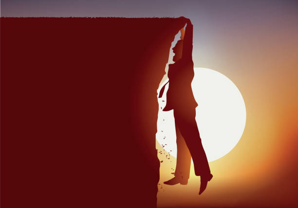 istock A man hangs himself above the void while standing at the edge of a cliff. 1172531412