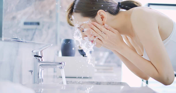 schoonheid vrouw wassen haar gezicht - gezicht wassen stockfoto's en -beelden