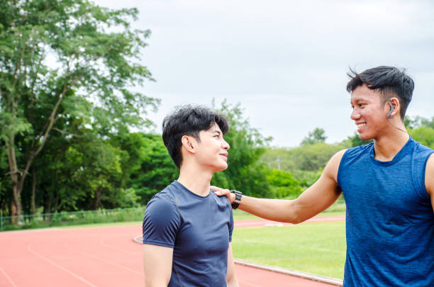 istock Two man runners standing talking after running and training exercise in stadium, talking and smiling while resting 1172535179