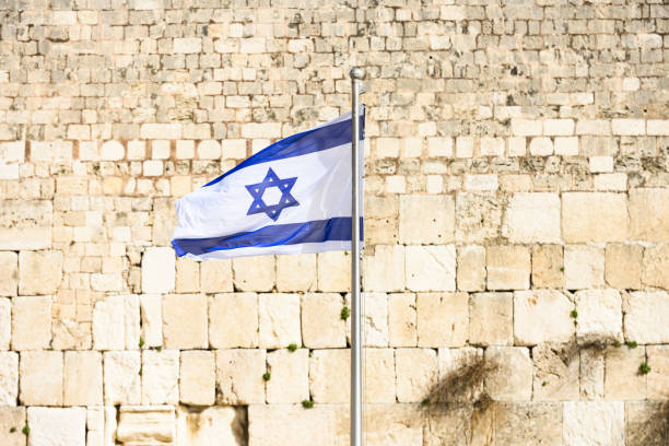 close-up view of the israeli flag waving in front of the western wall (wailing wall) in jerusalem, israel. the flag of israel can be seen all around the country, and is a symbol of joy and dreams. - european culture spirituality traditional culture famous place imagens e fotografias de stock