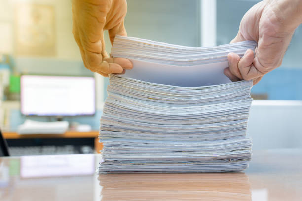 istock Hand of man is pulling or arrange of find documents from the stack. 1172536138