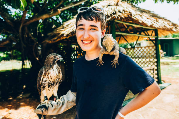 istock Teenage boy with hawk and iguana 1172549111