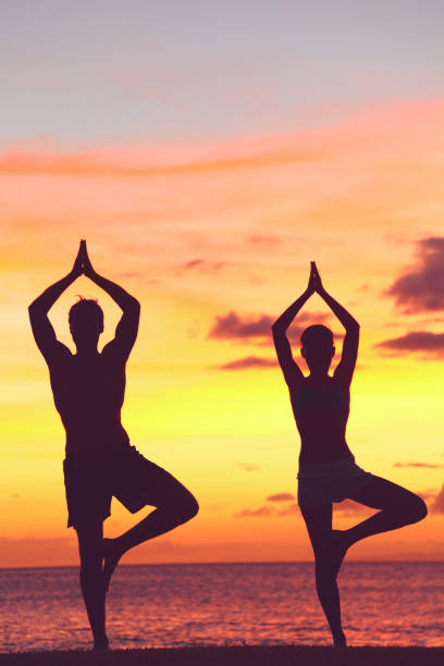 istock Yoga couple training in sunset in tree pose 1172557463