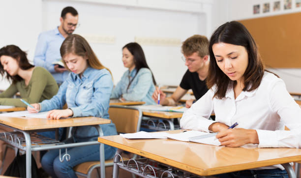 istock Girl writing test in classroom 1172557529