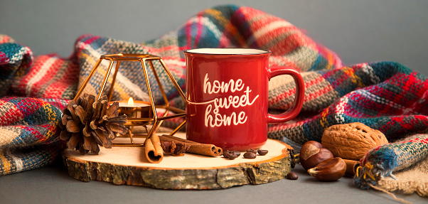 Autumn coffee cup with candle, spices and blanket decorations on wooden board, cozy fall deco concept, home lifestyle warm coffee cup in autumn season