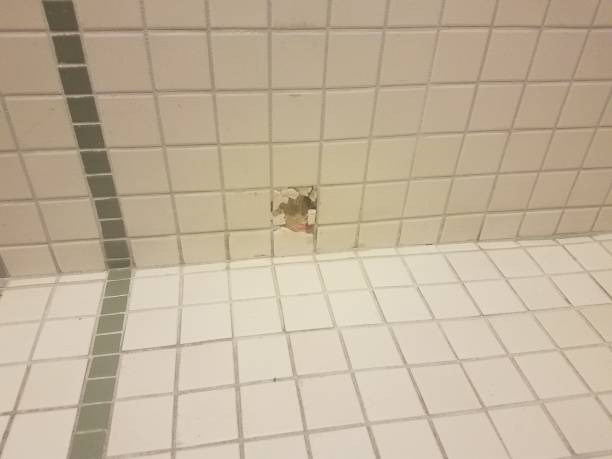 istock a hole in the white and green bathroom wall tiles 1172558791