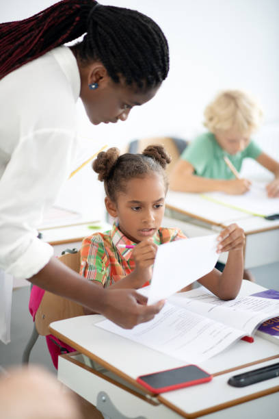 istock Dark-eyed girl correcting her mistakes after writing test 1172559646