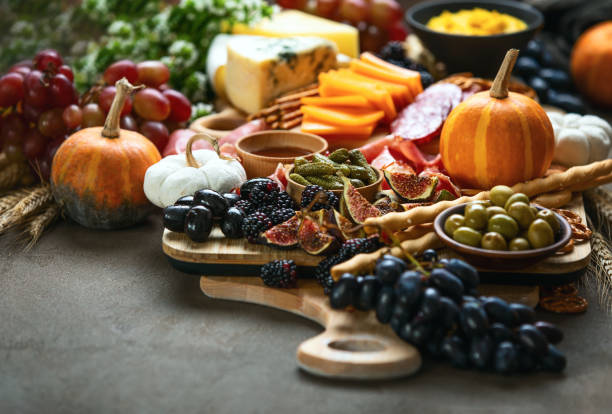 table de dîner de partie d'automne avec le conseil de charcuterie - multi colored picnic dinner lunch photos et images de collection