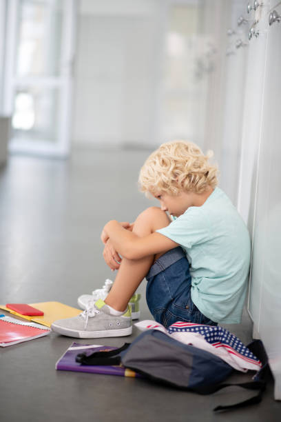 istock Schoolboy wearing denim shorts feeling isolated and lonely 1172559824