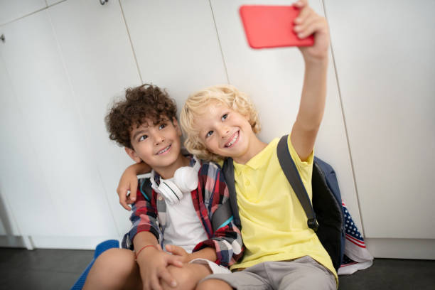 istock Blonde boy hugging best friend and making selfie together 1172560036