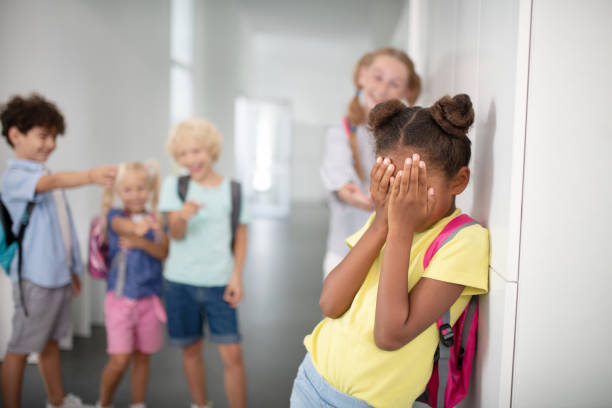 istock Dark-skinned girl closing her face while suffering from bullying 1172560143