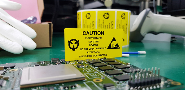 The yellow CAUTION label for Electrostatic Sensitive Devices (ESD) on static free workstation.