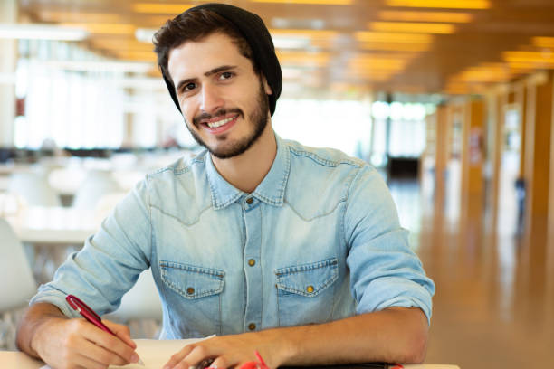 istock Young male student studying in the library. 1172562324